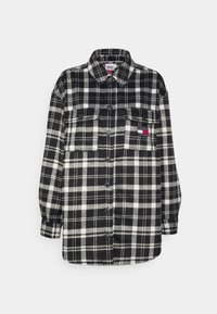 Black and white plaid flannel shirt with a button-up front, collar, two chest pockets, and a logo patch on the left pocket.