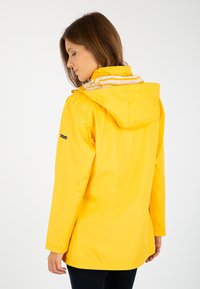 Veste de pluie jaune résistante à l'eau avec capuche, présentant des accents rayés blancs sur le col intérieur, et ayant un design à coupe décontractée.