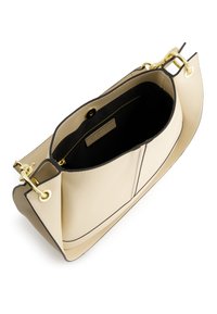 Cream leather tote bag with black accents, featuring gold hardware, an open top, and a black interior with a label for added detail.