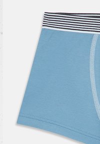 Lyseblå bokser-shorts med stripete midjebånd. Materialet er glatt, med en tettsittende design og flatlock-søm.