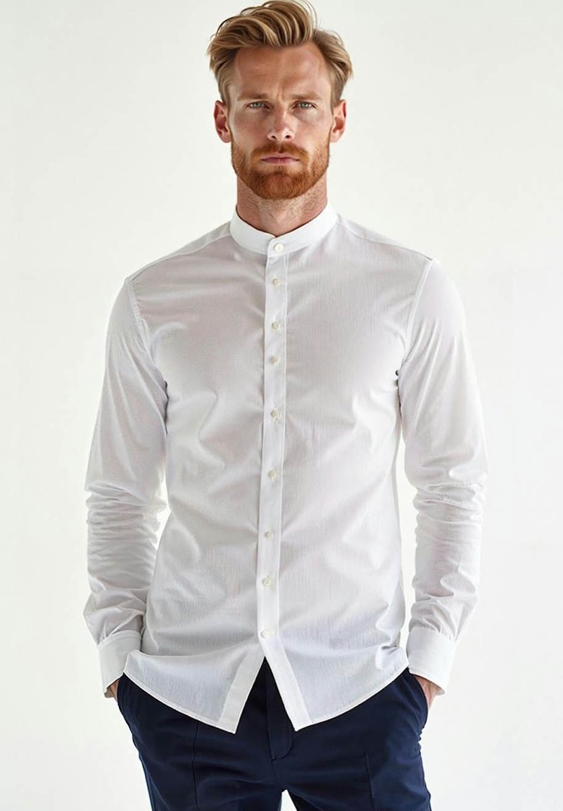 Biała koszula zapinana na guziki z kołnierzykiem stojącym, długim rękawem, subtelną teksturą i dopasowanym krojem. W zestawie z ciemnymi spodniami.