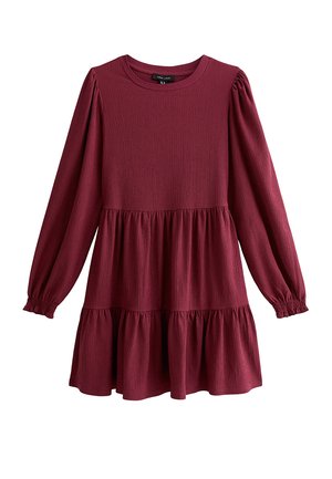 Robe bordeaux à manches longues avec une texture côtelée, un col rond et une jupe à volants. Caractérisée par des manches froncées et une coupe décontractée.