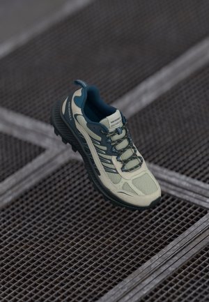Light green athletic shoe with a breathable mesh upper, dark teal accents, textured sole, and reflective details on the side and laces.