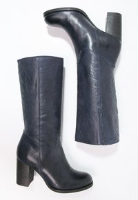 Bottes en cuir bleu foncé montant jusqu'aux genoux, avec un bout arrondi et un talon épais en bloc. Texture lisse et finitions minimalistes avec peu de coutures.