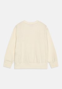 Felpa beige chiaro con scollo rotondo e polsini a costine. Il tessuto sembra morbido con una texture liscia, presentando un design semplice sul retro.