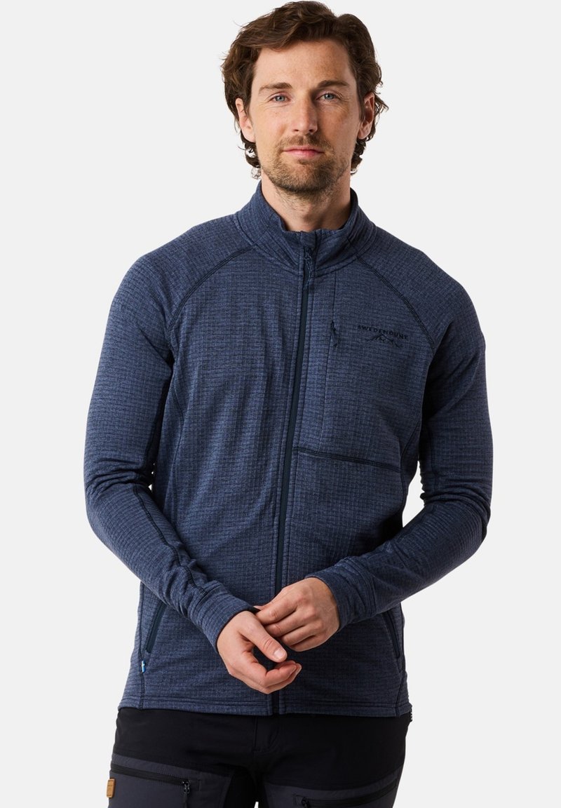 Fleece jas in donker marineblauw met een gestructureerd patroon, volledige rits, hoge kraag en een borstzak. Voorzien van lange mouwen en een aansluitende pasvorm.