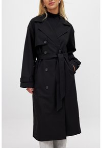 Cappotto nero in tessuto liscio, con colletto a risvolto, design doppiopetto, cintura in vita e polsini con bottoni.