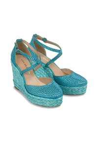 Sandali con zeppa turchesi realizzati in materiale intrecciato, decorati con strass blu, dotati di cinturini incrociati e una suola texturizzata.