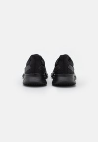 Le scarpe da atleta nere presentano una tomaia in mesh traspirante, accenti texture e una suola nera imbottita. Il design è elegante e minimalista.