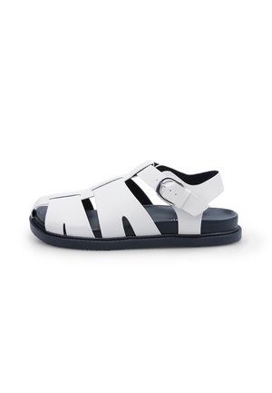 Hvid læderfisker sandal med åben tå, justerbar sølvspænde og sort polstret sål.