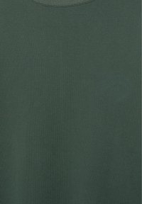 Tummanvihreä, kuvioimaton ja logoton pyöreäkauluksinen kangas, jonka tekstuuri ja ompelusauman yksityiskohdat näkyvät kaula-aukossa.