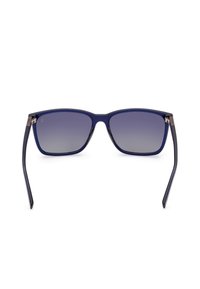 Gafas de sol rectangulares con un marco de plástico azul marino y lentes grises degradados. Patillas delgadas negras con acentos de hardware plateados.