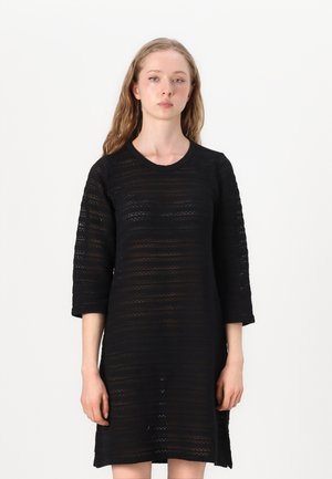 Rochie neagră tricotată cu mâneci trei sferturi, având un model texturat în dungi și un decolteu rotund. Design ușor și lejer.