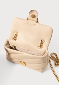Borsa a tracolla in pelle beige con catena, dotata di chiusura a scatto, accessori in oro e una tasca interna con zip e una fodera morbida.