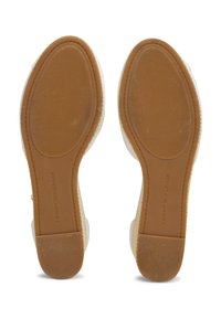 Witte sandalen met rubberen zool en een gestructureerde bruine buitenzool, met een prominent merklong en een gladde bovenkant met een afgeronde vorm.