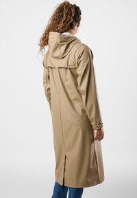 Vesimproof beige sadeviita, jossa on huppu, pitkät hihat ja nappilukitus. Varustettu takaventtiilillä ilmavirran varmistamiseksi ja sileällä, kiiltävällä pinnalla.