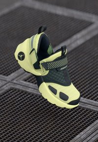 Rumeno-črni Jordan atletski športni copat z Velcro trakovi, mrežasto zgornjo plastjo in zanka za zatiskanje na kovinski rešetki.