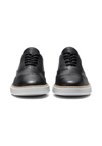 Scarpe in pelle nera con profilo basso, punta arrotondata e dettagli cuciti. Presentano una suola in gomma bianca e il classico design con lacci.