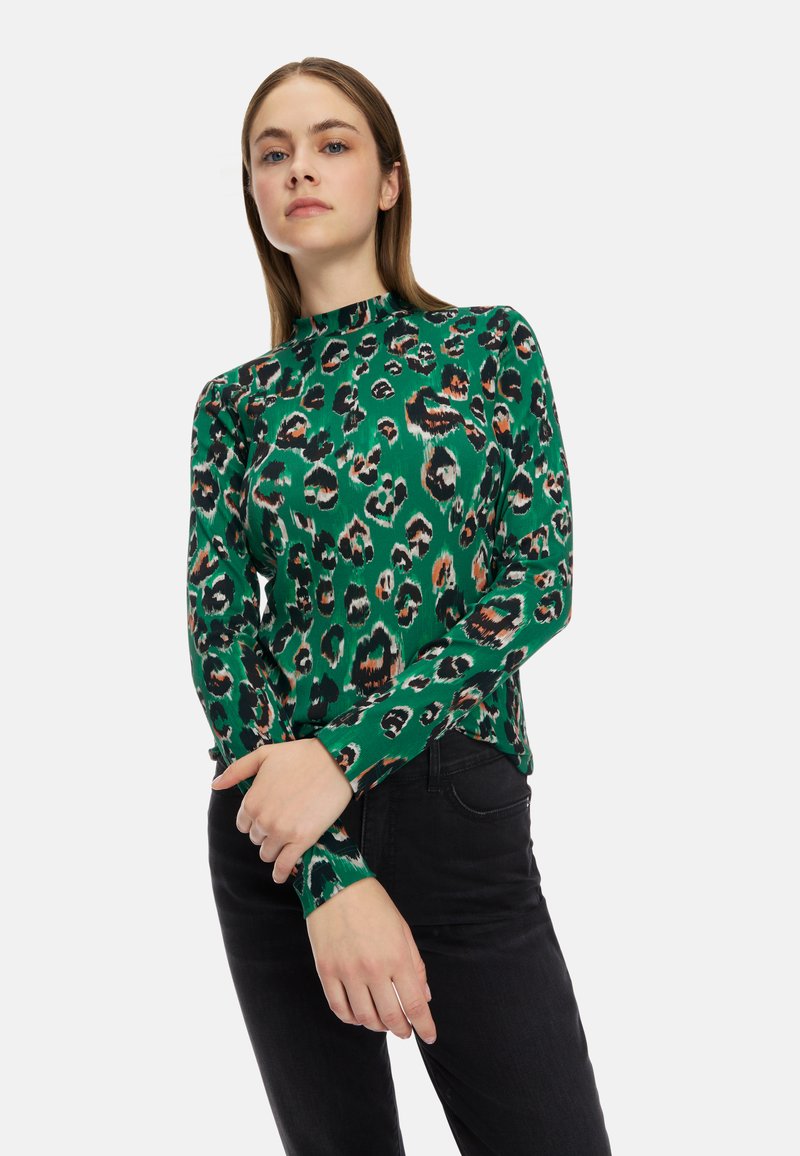Grünes Langarmoberteil mit einem Leopardenmuster in Schwarz und Orange. Hergestellt aus einem glatten Stoff mit einem hohen Kragen und einer taillierten Passform.