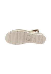 La suola delle sandali presenta un materiale in gomma beige con superficie testurizzata, scanalature a motivo per la trazione e un design flessibile e curvato.