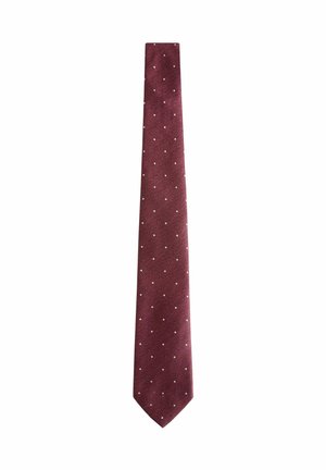 Cravate bourgogne en tissu texturé, présentant des pois blancs régulièrement espacés. Design slim avec une extrémité effilée, adapté pour des tenues formelles.