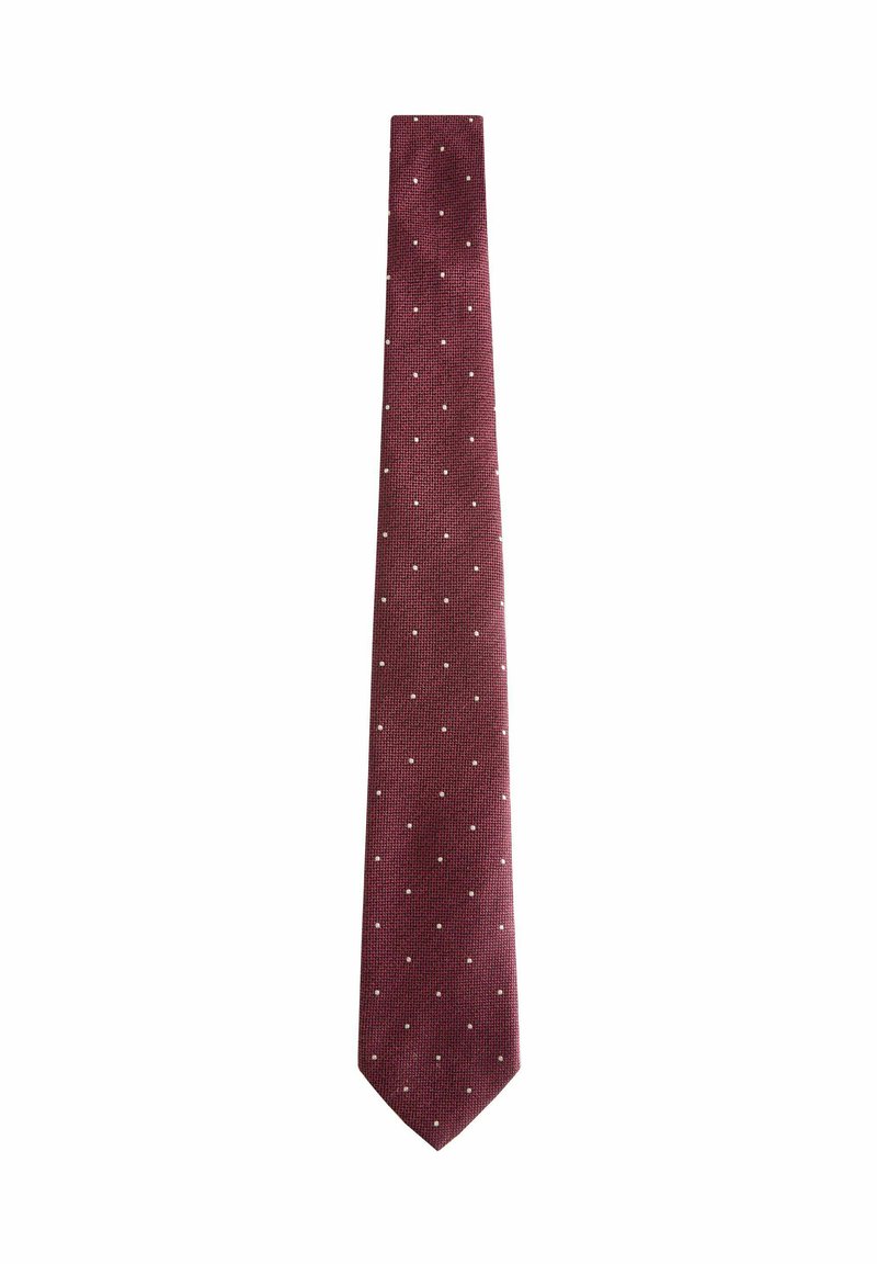 Cravate bourgogne en tissu texturé, présentant des pois blancs régulièrement espacés. Design slim avec une extrémité effilée, adapté pour des tenues formelles.