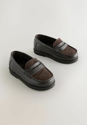 Tumepruunist nahast ja sametist loaferite paar, millel on õmblustega detailid ja rihm ülevalt, esitatud heledal taustal.