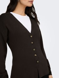 Brauner Cardigan mit V-Ausschnitt, geripptem Muster und sechs passenden Knöpfen vorne. Lange Ärmel und lockere Passform.