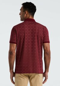 Bordeaux polo shirt met een geometrisch patroon, korte mouwen en een gestructureerde kraag. Inclusief zijslitsen aan de onderkant voor gemakkelijke beweging.