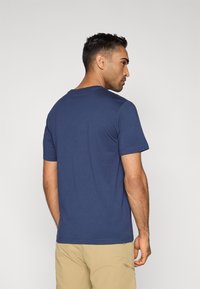 Μπλε ναυτικό κοντομάνικο t-shirt με κλασικό στρογγυλό λαιμό, κατασκευασμένο από απαλό ύφασμα, με λεία επιφάνεια και χαλαρή εφαρμογή.