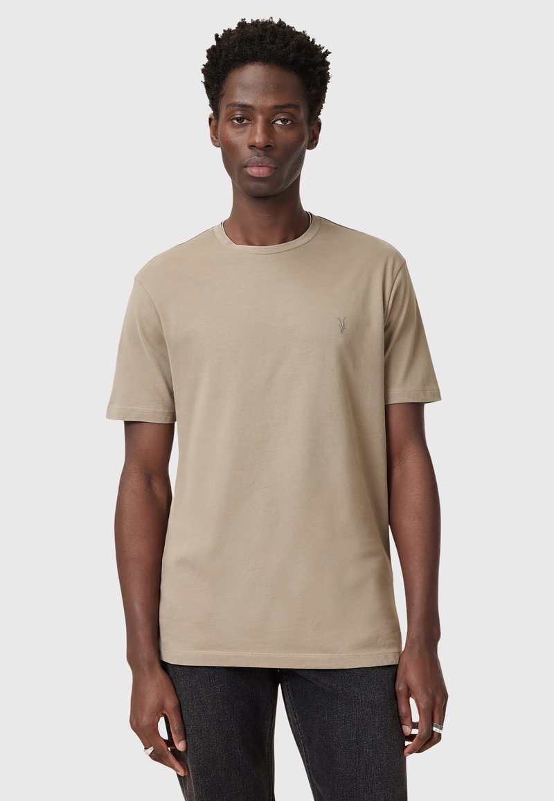 Beige cotton t-shirt with a crew neck and short sleeves, featuring a small embroidered logo on the chest. Classic fit, soft texture.