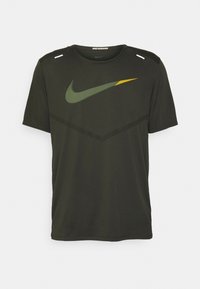 Camiseta de running Nike de color verde oscuro con mangas cortas, que presenta un tejido texturizado, un prominente logo de Nike en verde y amarillo, y un cuello redondo.