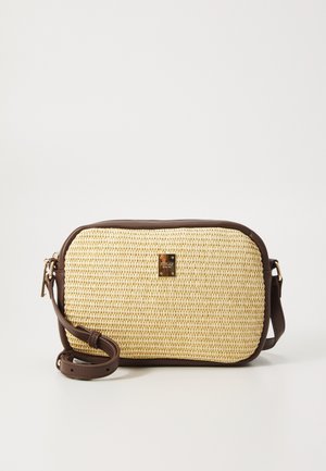 Sac bandoulière en paille tissée avec des bords en cuir marron, de forme rectangulaire arrondie, comportant un accent en métal logo et une bandoulière réglable.