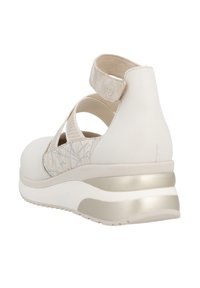 Baskets blanches avec des sangles croisées, détail en maille sur les côtés, cheville rembourrée et semelle avec accents métalliques. Matière supérieure légèrement texturée.