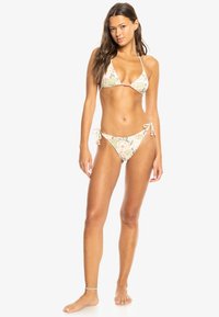 Dried driehoek bikini in een bloemenpatroon, met lichte kleuren, strikjes aan de zijkanten en kraaltjes bovenaan, gemaakt van soepele stof.