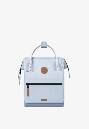 Light blue backpack made of durable fabric, featuring double handles, a front zipper pocket, and a circular logo patch.