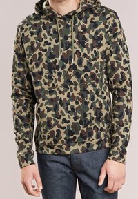 Felpa con cappuccio camouflage in morbido misto cotone. Presenta un cappuccio con coulisse, una grande tasca frontale a marsupio e polsini a coste nelle tonalità di verde e marrone.