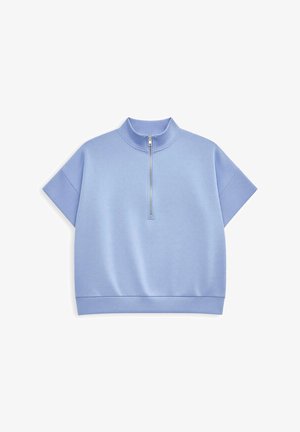 Jasnoniebieska bluzka z krótkim rękawem, wysokim kołnierzem i półzamkiem z przodu. Wykonana z miękkiego materiału o gładkiej strukturze i ściągaczu na dole.
