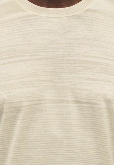Πουλόβερ πλεκτό κρέμ χρώματος με στρογγυλή λαιμόκοψη, με διακριτικές οριζόντιες ρίγες και απαλή υφή. Απλός σχεδιασμός χωρίς λογότυπα.