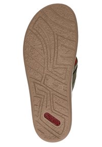 Shoe outsole featuring a textured brown rubber bottom with a tread pattern, logo detail in red, and a green fabric upper edge.