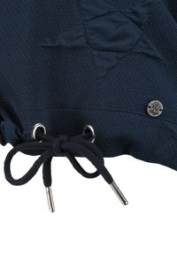 Marineblauwe stof met gestructureerd patroon, voorzien van zilveren ogen en een zwarte trekkoord met aglets. Inclusief kleine metalen accent met merk.