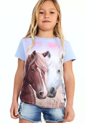 Young girl wearing a blue t-shirt featuring a realistic print of two horses, one brown and one white, with pink heart shapes above them.