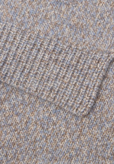 Primo piano di due calzini lavorati a maglia in filato beige e azzurro chiaro, con risvolto a coste e punti testurizzati.