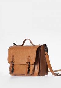 Sacoche en cuir marron clair avec boucles à l'avant, poignée supérieure et sangle d'épaule réglable sur un fond blanc uni.