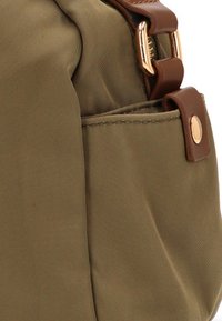 Bolsa de tela verde oliva con acentos de cuero marrón, con cierre de cremallera, bolsillo lateral y detalles de hardware en tono dorado.
