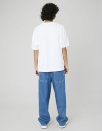 T-shirt blanc à manches courtes avec un col rond, associé à un jean large bleu avec poches arrière. Design simple, en matière coton.