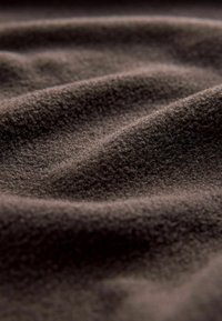 Tissu marron foncé avec une surface douce et texturée, présentant de douces ondulations et un aspect finement velouté. Pas de motifs ou d'accents distincts.