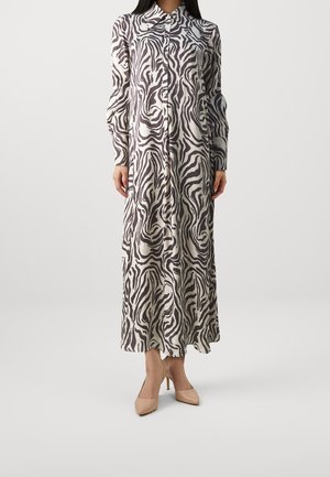 Long-sleeve, buttoned, ankle-length dress with black and white zebra print paired with beige pointed-toe heels on a plain background.