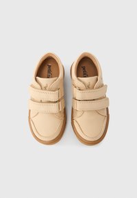 Μπεζ δερμάτινα παπούτσια για νήπια με δύο ιμάντες Velcro και καφέ λαστιχένιες σόλες, εμφανιζόμενα από πάνω σε απλό λευκό φόντο.