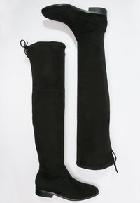 Botas negras de ante sobre la rodilla, con tacón plano, cordón ajustable en la parte superior y una textura suave en toda su superficie.